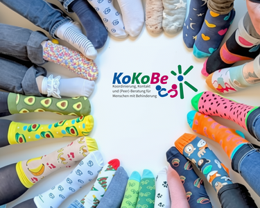 Foto mit im Kreis platzierten bunten Socken, in der Mitte das Logo der KoKoBe