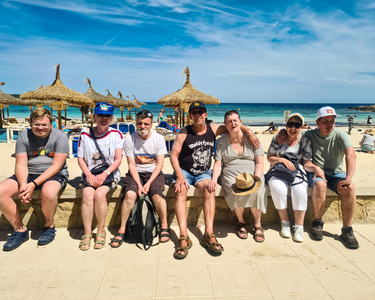 Mehrere Bewohner sitzen gemeinsam am Strand.