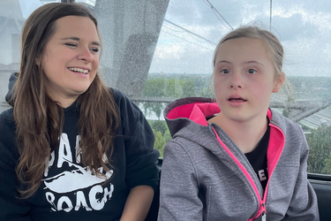 Bewohnerin und Betreuerin sitzen nebeneinander im Riesenrad.